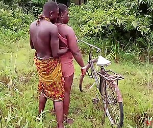 Okonkwo nosti kyläslay kuningatarin polkupyörällään, nai ulkona
