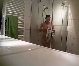 Ahnungsloses mädchen nimmt eine dusche aufgenommen