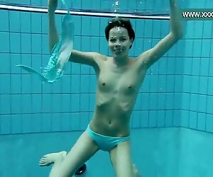 Podvodkova plávanie v modrých bikinách v bazéne