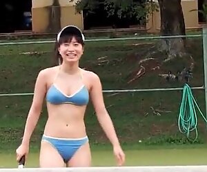 Bellas japonesas juega en bikini en la cancha de tenis.